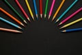 Colored pencils arranged in a semicircle on a dark background Royalty Free Stock Photo