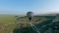 Top view of colorful balloon over green field. Shot. Bright colorful ball rises over green field at dawn. Balloon rises Royalty Free Stock Photo