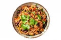 Top view of a colorful bowl of Mexican rice and beans garnished with cilantro presented on a white surface,