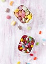 Top view of colorful candies and jelly beans in two white ceramic bowls. Sweet food concept. Copy space. Royalty Free Stock Photo