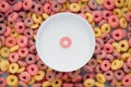 Top view of colorful cereal rings and a bowl of milk