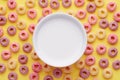 Top view of colorful cereal rings and a bowl of milk