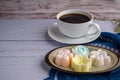 Top view of colorful coconut milk jelly on a plate on a blue cloth with a white coffee cup background. Concept of Thai dessert Royalty Free Stock Photo