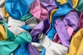 Top view of colorful deflated balloons texture background. Pile of multiple colorful unblown balloons pattern. Heap of colorful