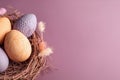 Top view of colorful easter eggs on bird nest. Pink background with copy space. Easter background