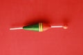 Top view of a colorful fishing rod bobber on a red background