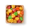 Top view of colorful hard candies in wooden bowl