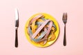 Top view of colorful measuring tapes on plate in the form of spaghetti with knife and fork on pink background. Weight loss and Royalty Free Stock Photo