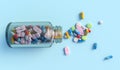 Top view of colorful medical drugs and medicines transparent bottle on light blue backdrop