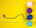 Top view of colorful nylon thread balls on yellow background. Concept of individuality