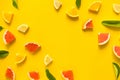 Top view of colorful orange fruit on yellow pastel background.