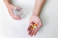 Top view of Colorful pills, capsule medicines and glass of water in man`s hands. Treating COVID-19 at home on the doctor`s Royalty Free Stock Photo