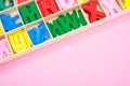 Top view of colorful wooden letters in their case, placed on a pink surface Royalty Free Stock Photo