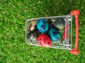 Top view of colourful of multi easter eggs in red shopping cart on green grass