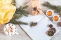 Top view composition with cup of coffee and marshmallow, dried orange, candles, spruce branches, gift, notepad and copy space.