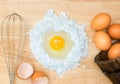 Top view composition flour with egg and ingredients for homemade bakery on wooden background