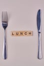 Top view of composition with fork, knife and inscription lunch on wooden blocks. Royalty Free Stock Photo