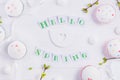 Top view composition of Hello spring lettering, branches with young shoots of greenery, easter cupcakes, merengue sweets, handcraf