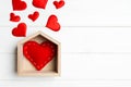 Top view composition made of red heart in a house surrounded with small hearts on wooden background. Home sweet home concept. Royalty Free Stock Photo