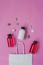 Top view composition of small travel bottles for cosmetics, shower gel, shampoo and hair balm and sea pebbles, peek out of the pac