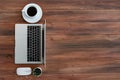 Top view of Computer laptop and coffee cup on wooden desk for work from home