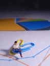 Top View, Conceptual Close Up Photo, Mini Figure toy Man Holding Smartphone, Sit at paperclip, Check Business Report