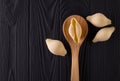 Top view of conchiglie pasta shells on black wooden table with spoon Royalty Free Stock Photo