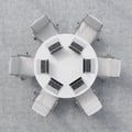 Top view of a conference room. A white round table, six chairs. Six laptops are on the table. Office interior.