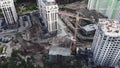 Top view of construction site with cranes and unfinished buildings of modern residential complex in forest. Cranes work at constru