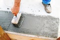 Top view of construction worker using paint brush for applying waterproof sealant