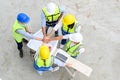 Top view of contractors, engineers and formats team in safety vests with helmets working with laptops, standing on under- Royalty Free Stock Photo