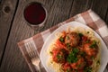 Top view on cooked spaghetti and meatballs on a wooden table with a glass of wine Royalty Free Stock Photo