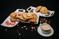 Top view of cookies on white plates with a cup of coffee on a black background Royalty Free Stock Photo