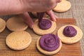 Top view of Cooking macarons cookies at home. Female hand squeezes cream on homemade cookie Royalty Free Stock Photo