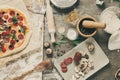 Top view cooking pizza with ingredients, tomatoes, salami and mushrooms on wooden tabletop Royalty Free Stock Photo