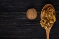 top view copy space peeled walnuts in a wooden spoon and in shell on a black wood background Royalty Free Stock Photo