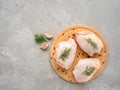 Raw chicken thighs on cutting board with ingredients for cooking at grey concrete kitchen table. Top view with copy Royalty Free Stock Photo