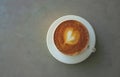 Top view and copy space of a tasty drinking, a cup of capuccino coffee decorated with heart pattern on brown milk froth in white