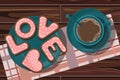 Top view of coral heart shaped cookies, coffee on the background of checkered towel on wooden table