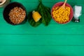 top view of corn seeds with cut corn salt and spinach on green background with copy space Royalty Free Stock Photo