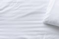 Top view corner of white pillow on white clean bed close up, Royalty Free Stock Photo
