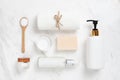 Top view of Cosmetic bottles, soap, wooden spoon and towel on white marble. Royalty Free Stock Photo