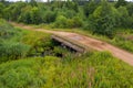 Top view of  the collapsing old bridge over an overgrown river Royalty Free Stock Photo
