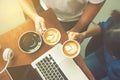 Couple hands holding coffee cup with notebook computer