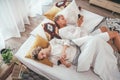 Top view of the couple lying in cozy bed in bedroom and browsing internet and checking mails using each other modern smartphone. Royalty Free Stock Photo