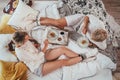 Top view of the couple in pajamas lazy relaxing lying in cozy bed in bedroom and having a morning coffee with apple pie dessert.