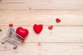 Top view couple red heart shape with mini shopping cart on wooden table. love, shopping and Valentine Day Royalty Free Stock Photo