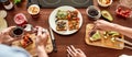 Top view of couple of vegetarians preparing various healthy toasts in the kitchen together. Man getting out sun dried Royalty Free Stock Photo