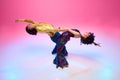 Top view. Couple wearing 70s disco fashion in dramatic back bend dance move against gradient pink studio background. Royalty Free Stock Photo