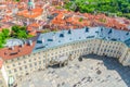 Top view of courtyard square of Prague Castle and Old Royal Palace with small figures of walking people tourists, red tiled roof Royalty Free Stock Photo